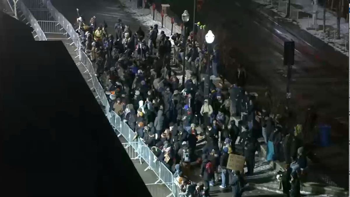 Crowd of protesters gathers along barricades outside a Minneapolis hotel near the University of Minnesota.
