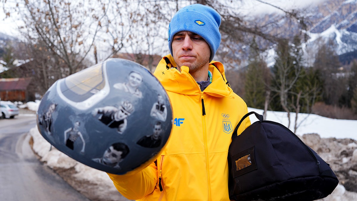 Ukraine's Vladyslav Heraskevych holds the helmet