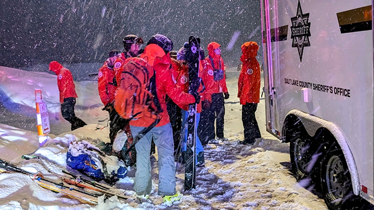 sheriff's personnel in snowy night standing by vehicle