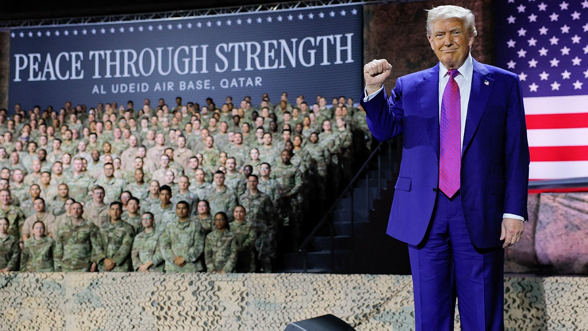 President Donald Trump raises his fist while visiting U.S. troops in Qatar