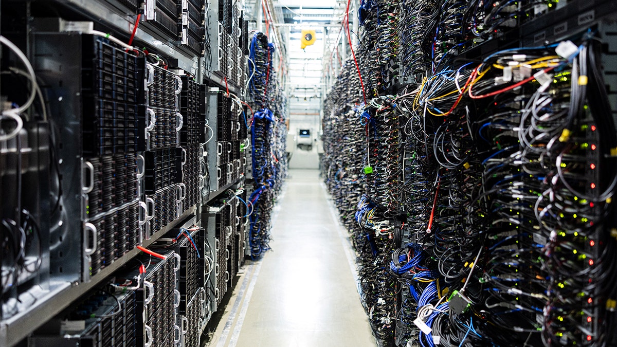 Racks of servers in a data center with colorful wires plugged into them.