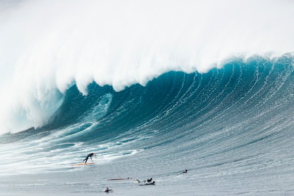 A surfer dives for cover as a large wave breaks off Wedding Cake Island, off Coogee Beach.