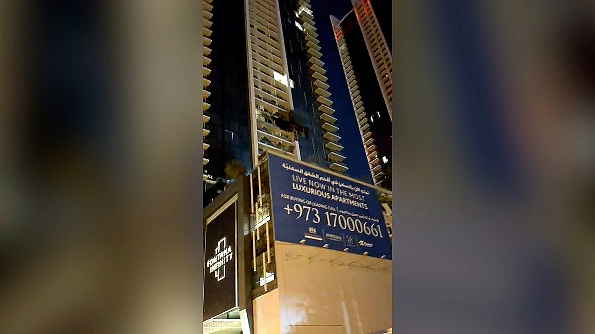 a massive gaping hole seen on the side of a residential high-rise building