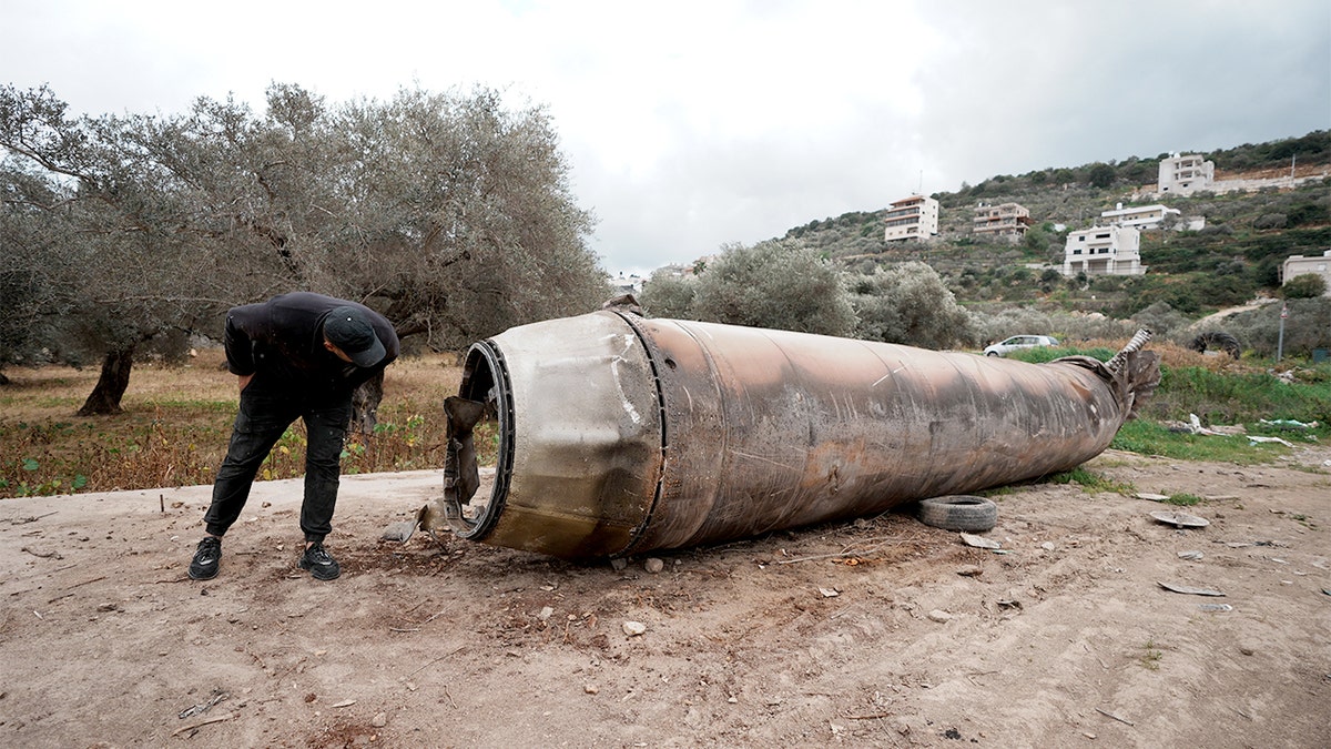 Twisted metal fragments from a downed projectile rest on the ground in a West Bank neighborhood after falling during a missile exchange.