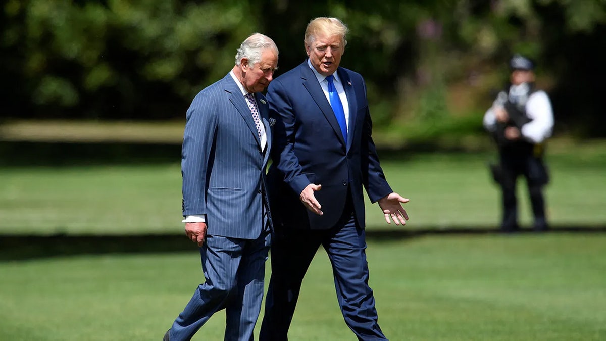King Charles and President Trump walking outside together.