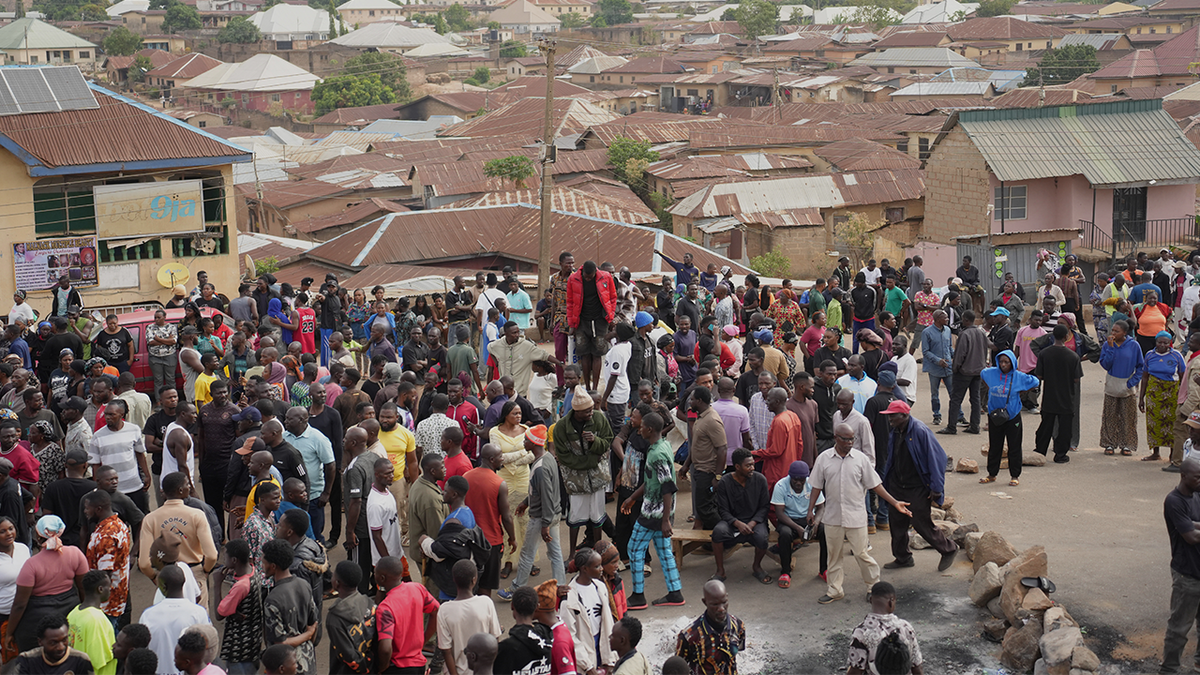 People gather at the scene of Sunday night gunmen attack in Gari Ya Waye community in the Jos North Nigeria, Monday, March 30, 2026.