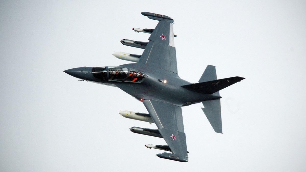 A Yak-130 jet performs aerial maneuvers during an airshow demonstration in southern England.