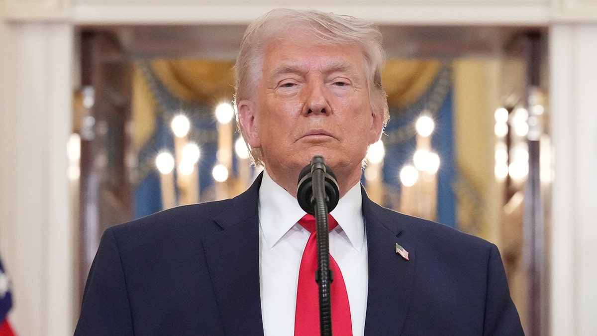 President Donald Trump pausing while speaking in the Cross Hall of the White House