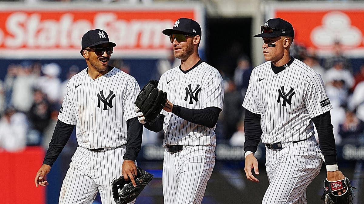 Trent Grisham Cody Bellinger and Aaron Judge celebrating on field at Yankee Stadium