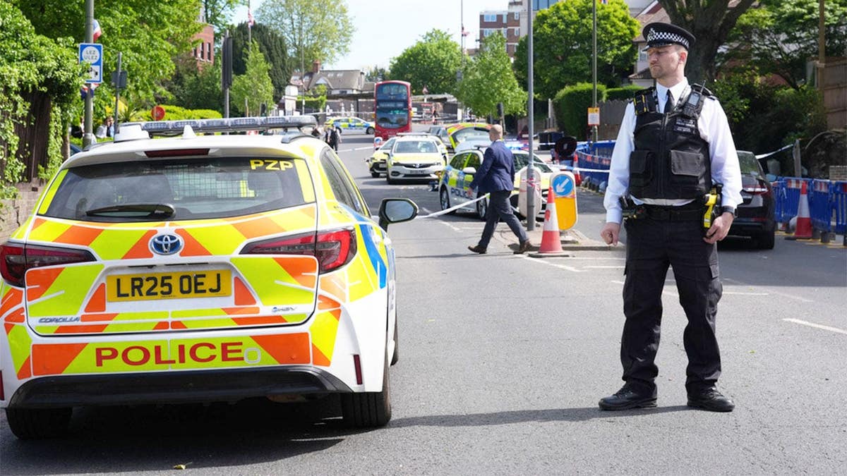 U.K. police officer standing near the crime scene.