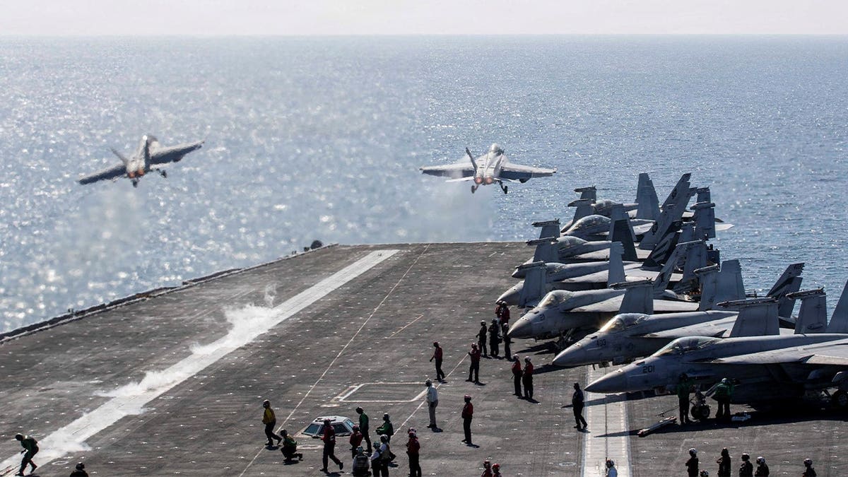 Two F/A-18 Super Hornets launching from USS Abraham Lincoln flight deck