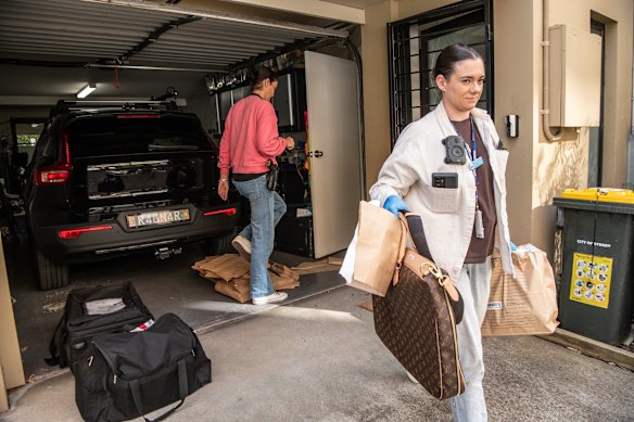 Luxury goods are carried away from Annalouise Spence’s home on Wednesday.