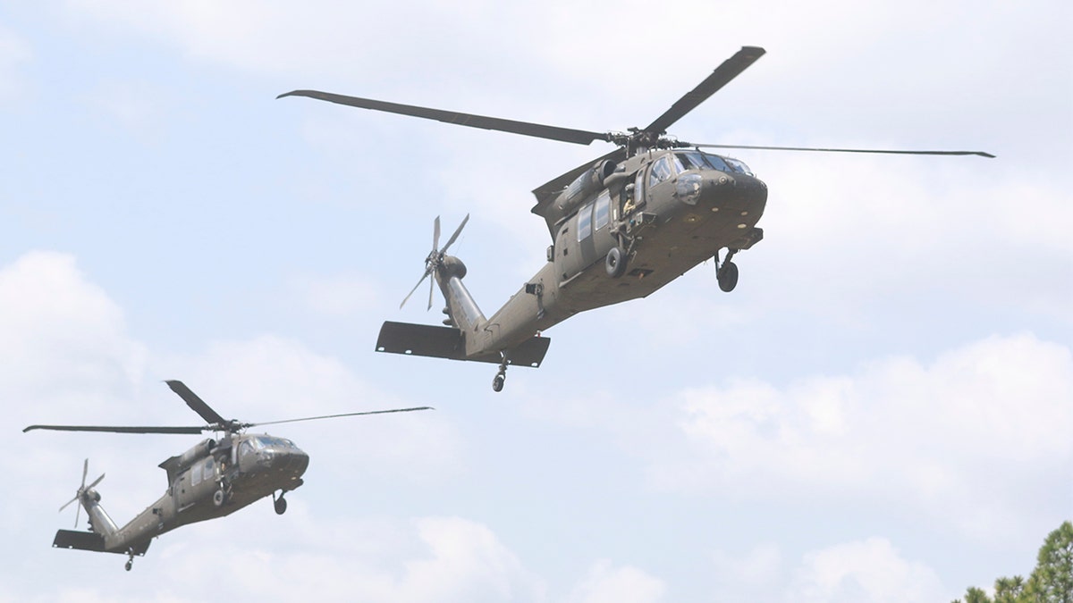 Two UH-60 Black Hawk helicopters preparing to land on flight strip at Fort Bragg