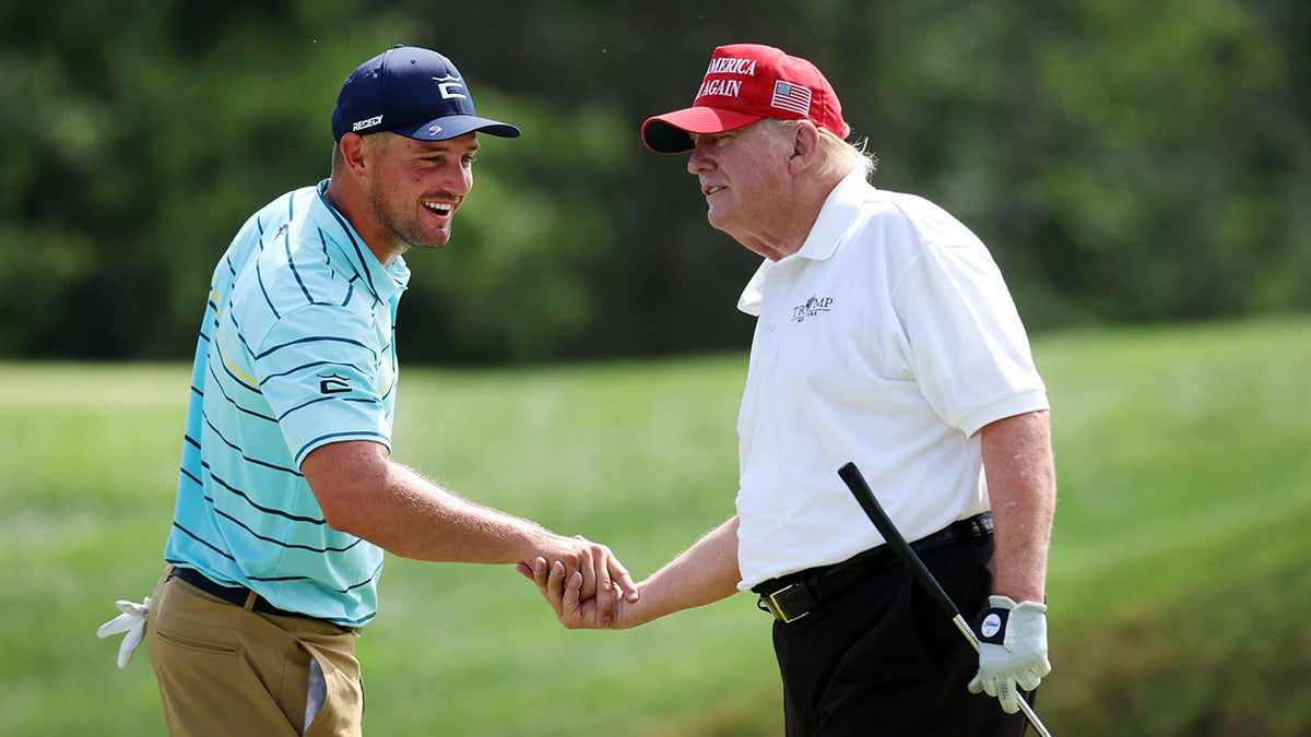 Team Captain Bryson DeChambeau shaking hands with former President Donald Trump on a golf course