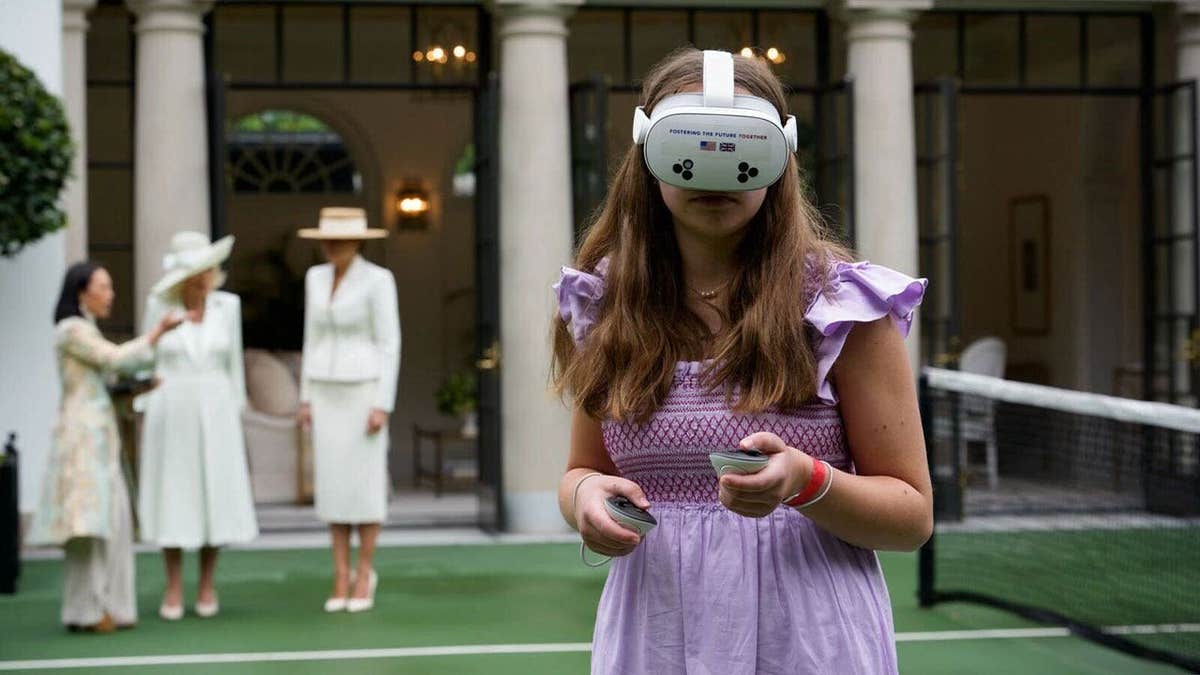A girl with VR googles with Melania Trump and Queen Camilla in the background
