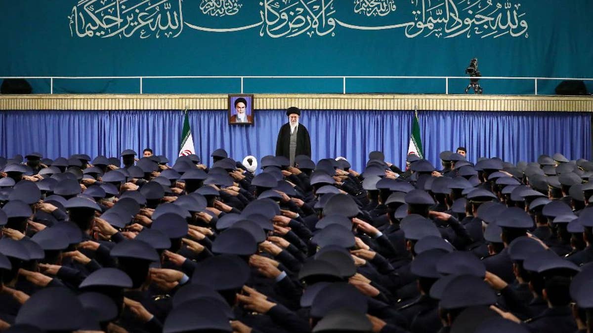 Supreme Leader Ayatollah Ali Khamenei standing as air force commanders salute in Tehran