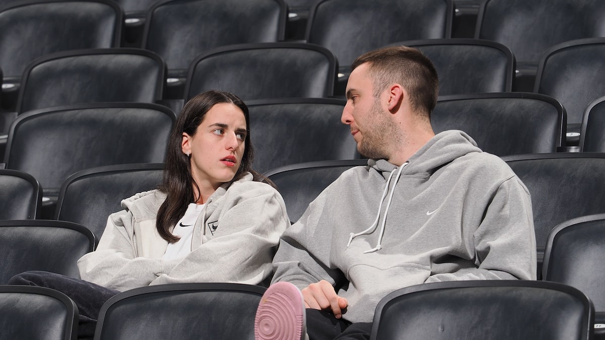 Caitlin Clark and Connor McCaffery seated courtside at Gainbridge Fieldhouse