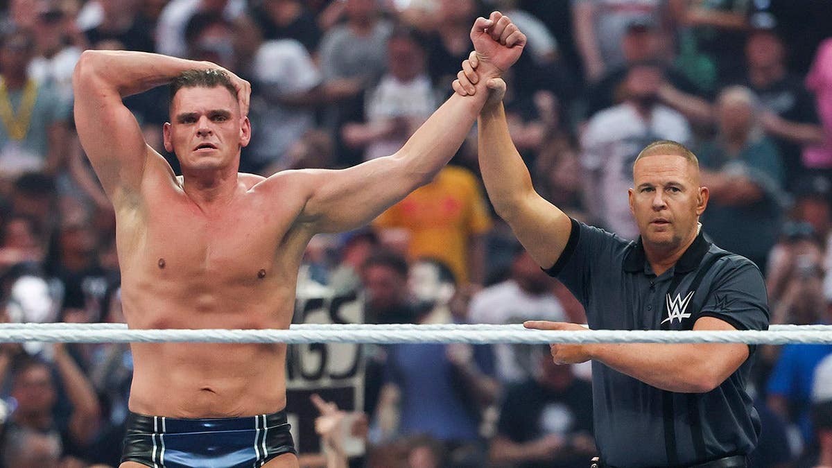 Wrestler Gunther with arm raised by referee at Allegiant Stadium in Las Vegas
