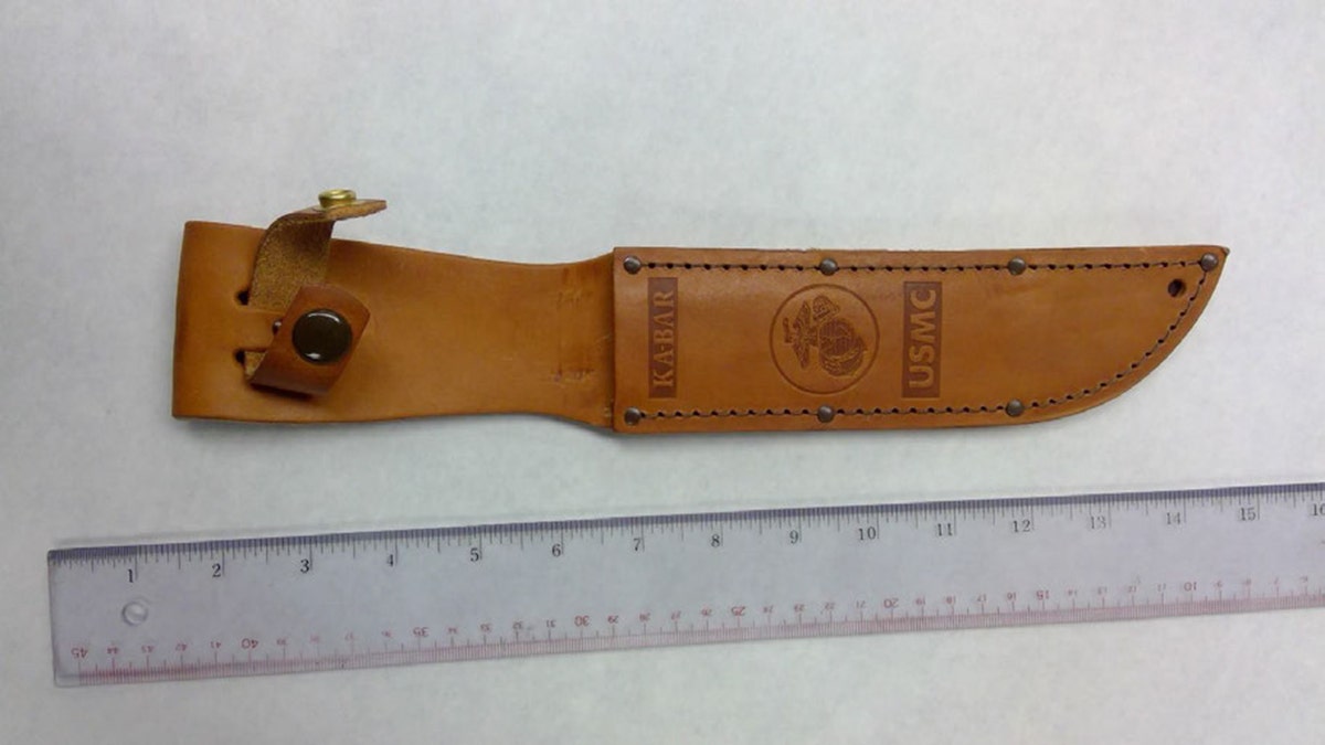 KA-BAR knife sheath displayed on a surface as evidence in a murder case