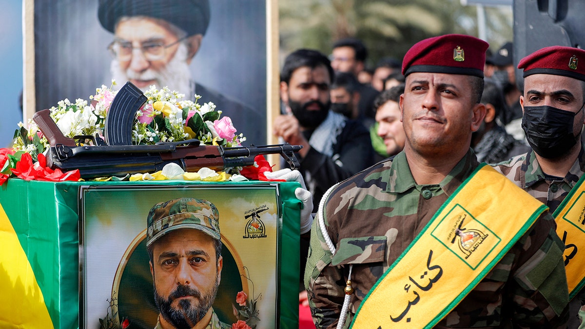 A mourner holding a portrait of Ayatollah Ali Khamenei during a funeral procession