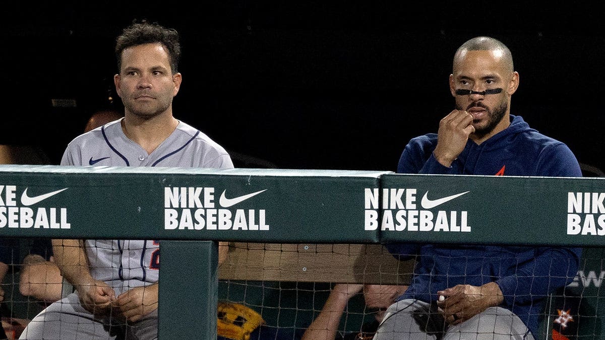 Jose Altuve and Carlos Correa watching from dugout during baseball game