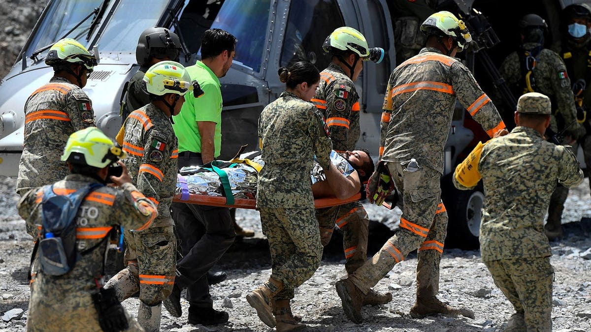 Miner Francisco Zapata Najera being carried on a stretcher by rescue team members