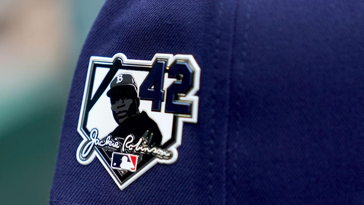 A Tampa Bay Rays hat with a Jackie Robinson Day patch on a baseball field.