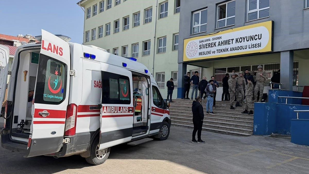 Turkish security forces and emergency staff standing in a high school courtyard
