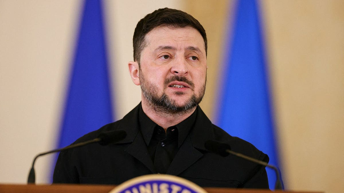 Ukrainian President Volodymyr Zelenskiy speaking at a podium during a press conference