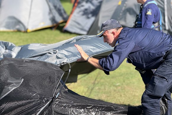 Police and council workers removing the camp at Victoria Park on Friday.