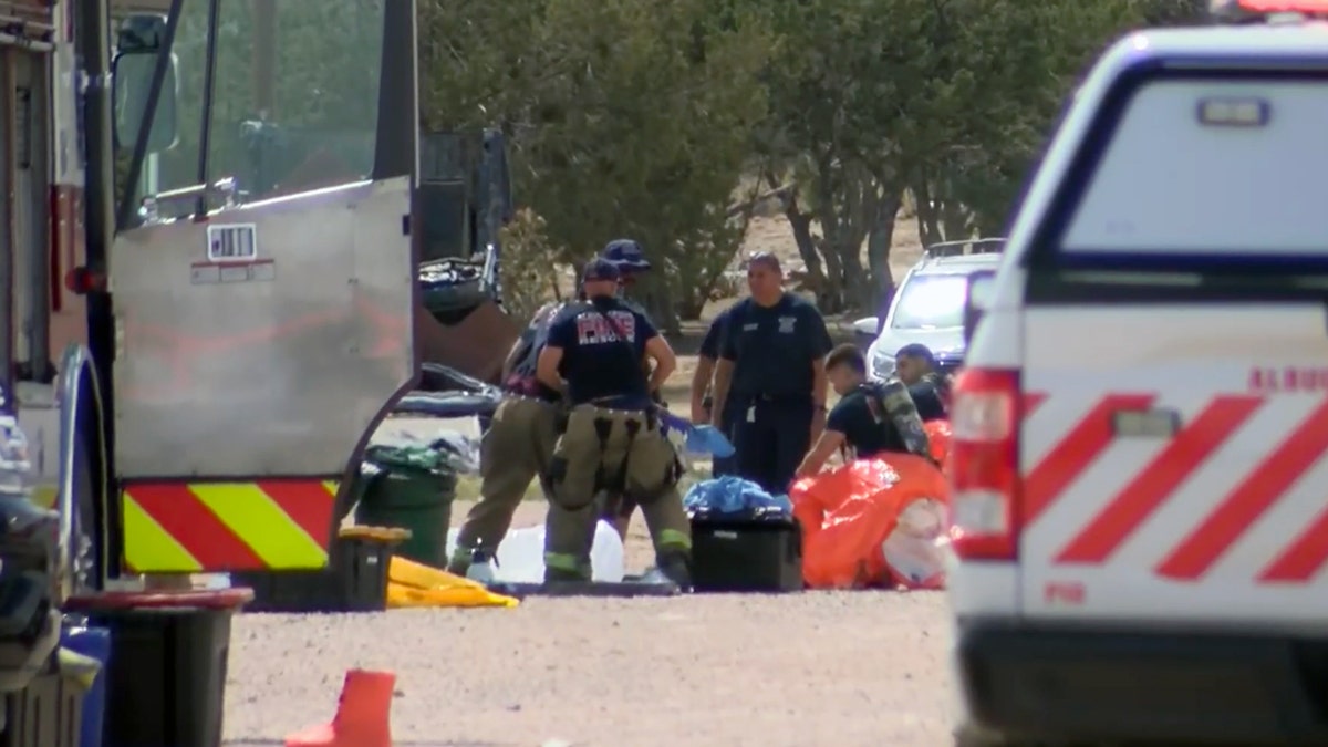 A hazardous materials team in protective suits investigating a chemical exposure site