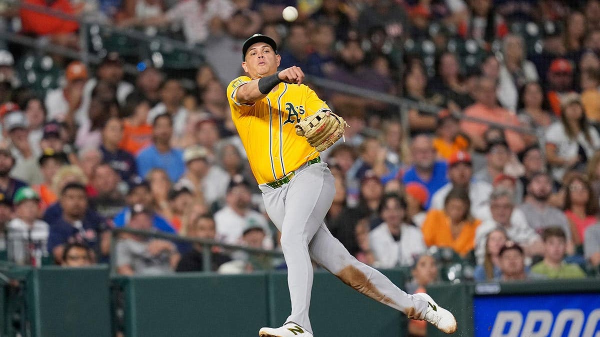Athletics third baseman Gio Urshela throwing to first base during a baseball game