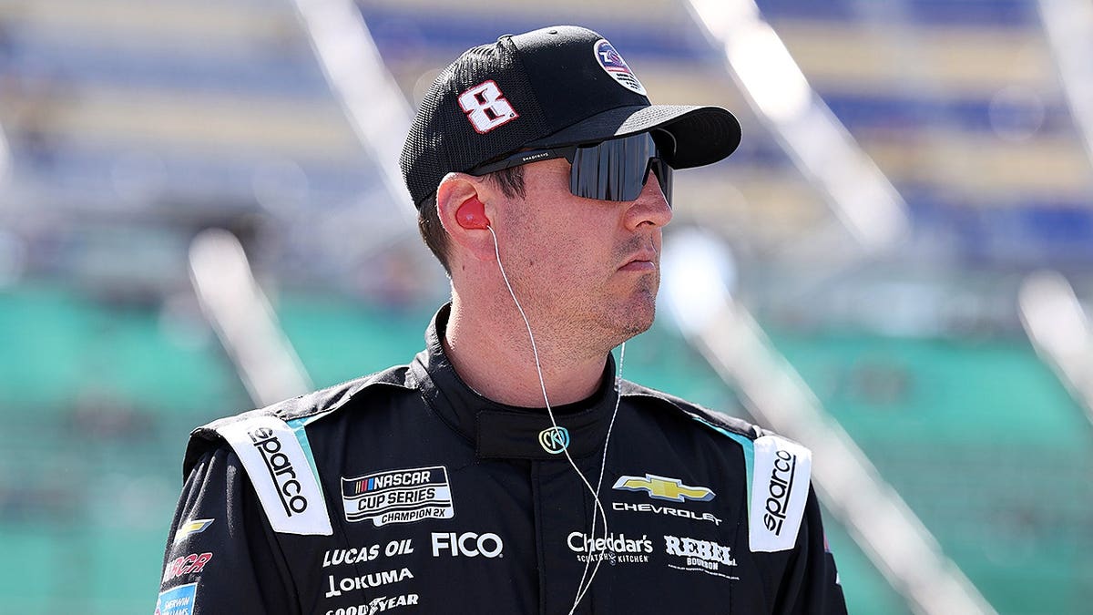 Kyle Busch standing near his #8 Nicokick x zone Cranberry Chevrolet at Kansas Speedway