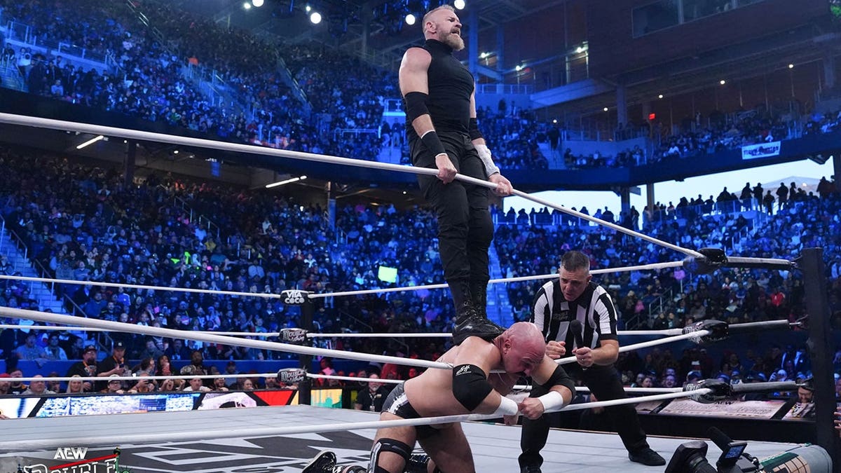 Christian Cage on top of Dax Harwood wrestling in a ring in Queens, New York