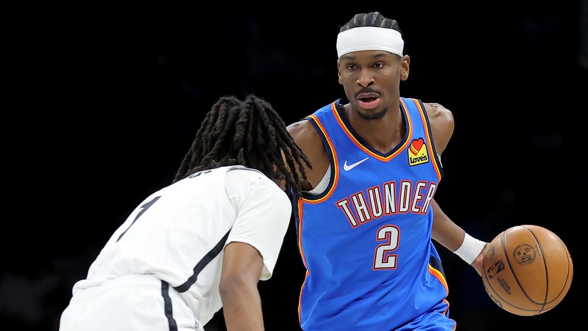 Shai Gilgeous-Alexander dribbling basketball against Ziaire Williams at Barclays Center