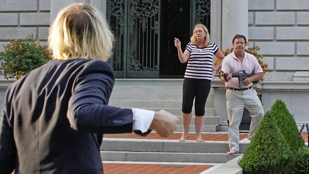 Patricia and Mark McCloskey holding firearms outside their home in St. Louis