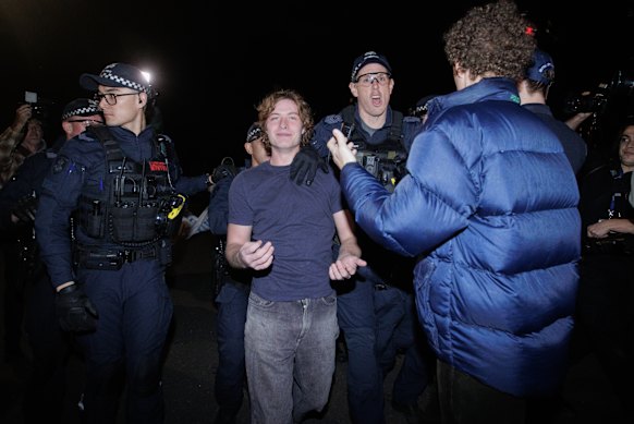 Police lead prominent neo-Nazi Michael Nelson away from protests outside the One Nation fundraiser.