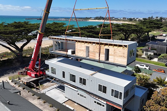 A modular home is craned into position.