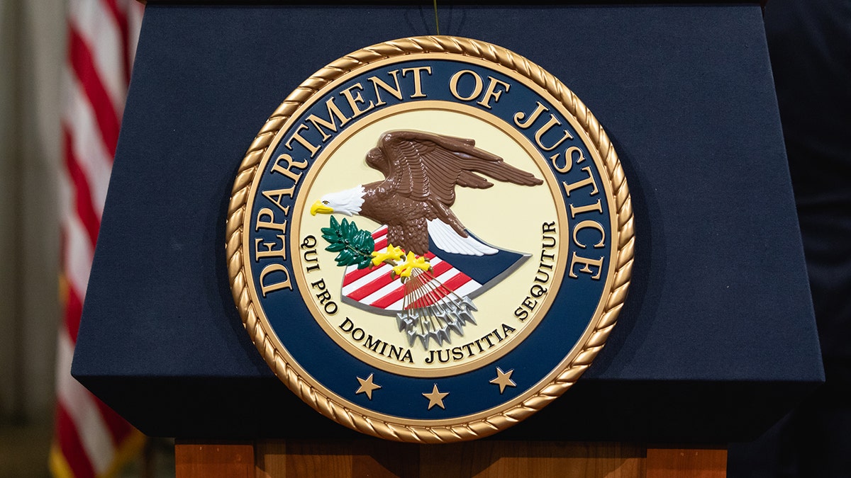 A a podium with the Department of Justice seal in Washington, D.C.