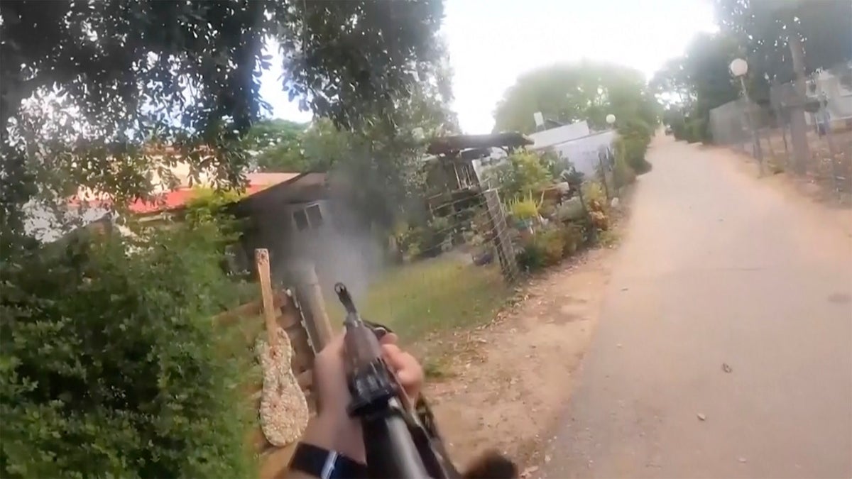 Hamas terrorist firing a weapon into a house on a kibbutz