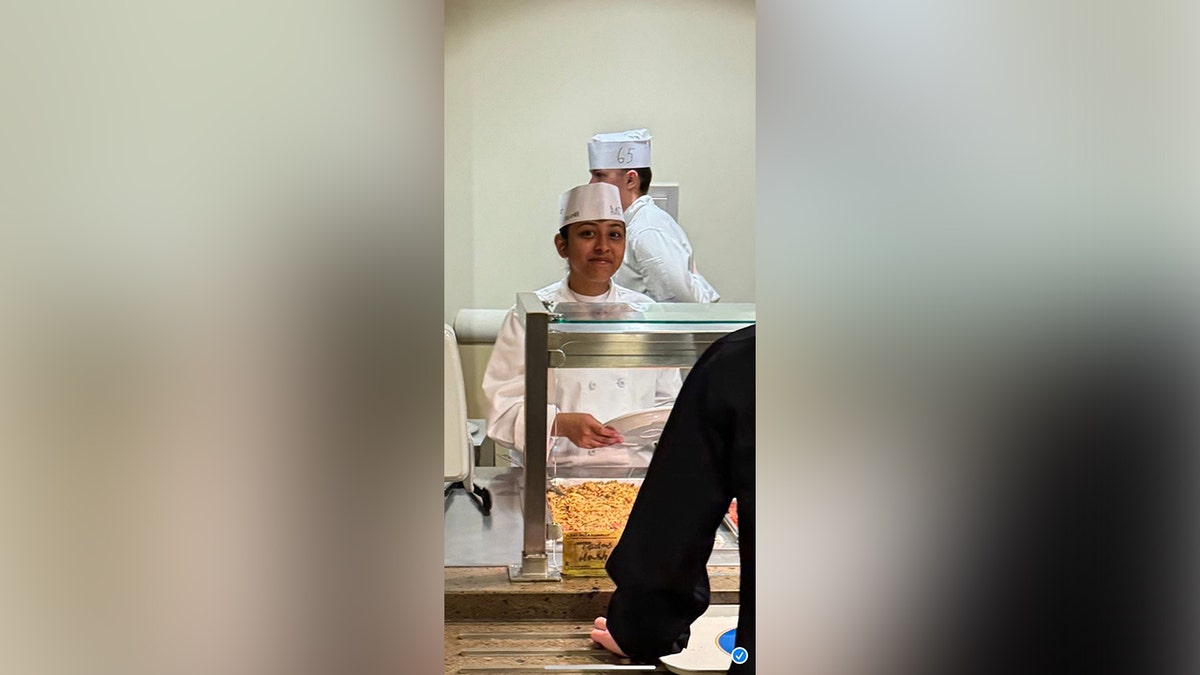 Angelina Resendiz stands behind a serving line while working in a Navy dining facility.