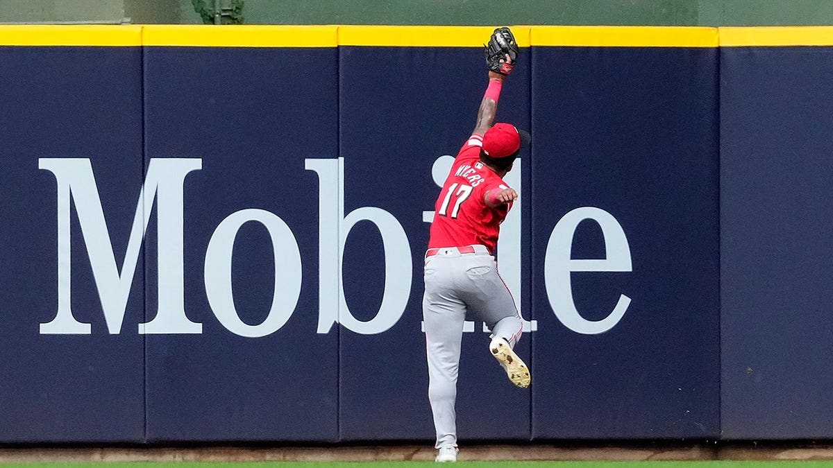 Dane Myers of the Cincinnati Reds making a running catch near the wall at American Family Field.