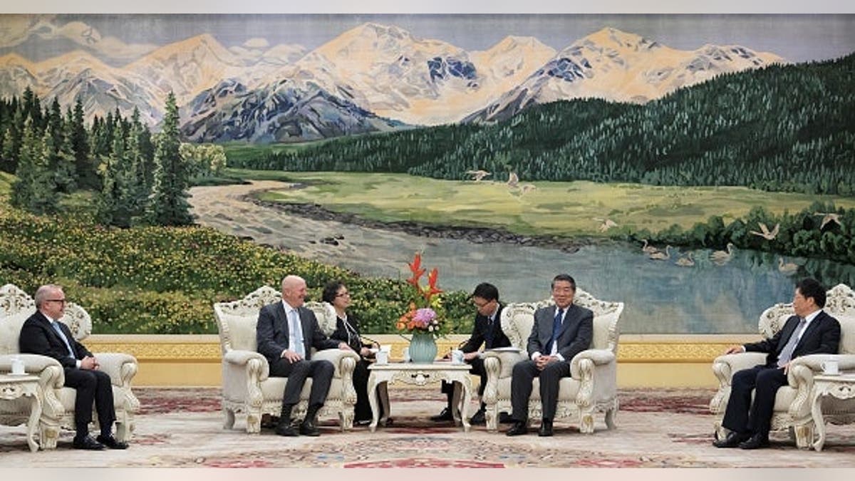 He Lifeng and David Solomon seated at a table during a meeting in Beijing