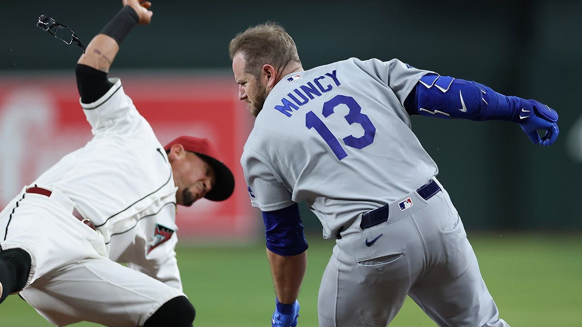 Max Muncy colliding with Ildemaro Vargas at first base during a baseball game.
