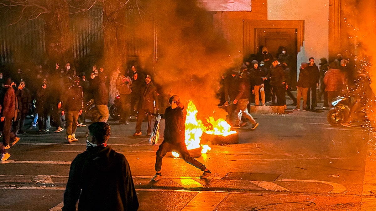 Iranians gathering and blocking a street during a protest in Tehran