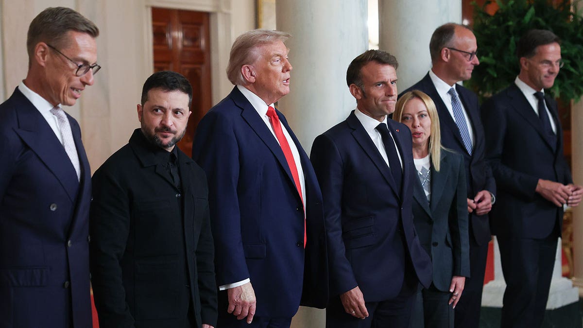 Finnish President Alexander Stubb, Ukrainian President Volodymyr Zelenskyy, U.S. President Donald Trump, French President Emmanuel Macron, Italian Prime Minister Giorgia Meloni, German Chancellor Friedrich Merz, and NATO Secretary-General Mark Rutte standing together at the White House