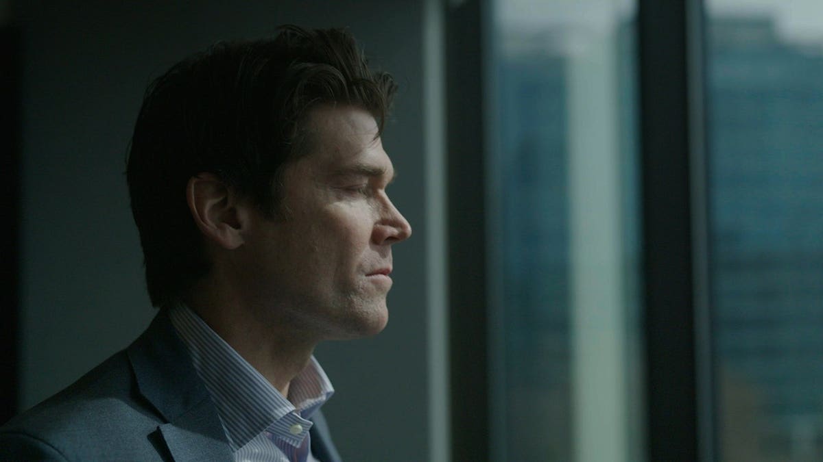 Chris Pixley looking at a window away from the camera.