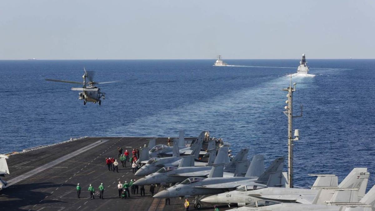 FILE - In this handout photo provided by the US Navy, The aircraft carrier USS Abraham Lincoln (CVN 72) transits the Strait of Hormuz as an MH-60S Sea Hawk helicopter from the Nightdippers of Helicopter Sea Combat Squadron (HSC) 5 lifts off from the flight deck.