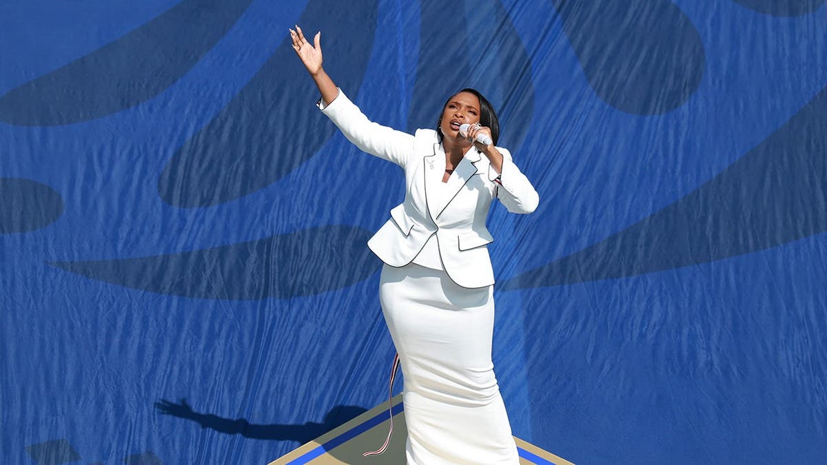 Jennifer Hudson performs the national anthem on a field.