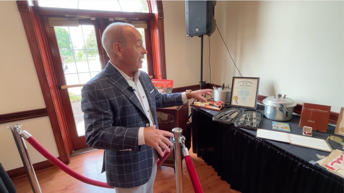 Auctioneer Bill Menish with memorabilia